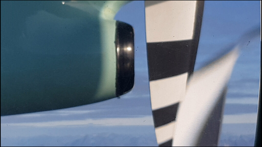 close up of a jet plane's engine and propellor against a blue sky